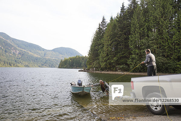 Zwei Männer lassen ihr Boot zu Wasser  bevor sie im Hicks Lake  Harrison Hot Springs  British Columbia  Kanada  angeln.