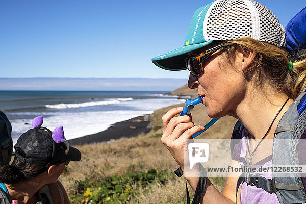 Female hiker drinking water while resting Lost Coast Trail Kings Range National Conservation Area California USA