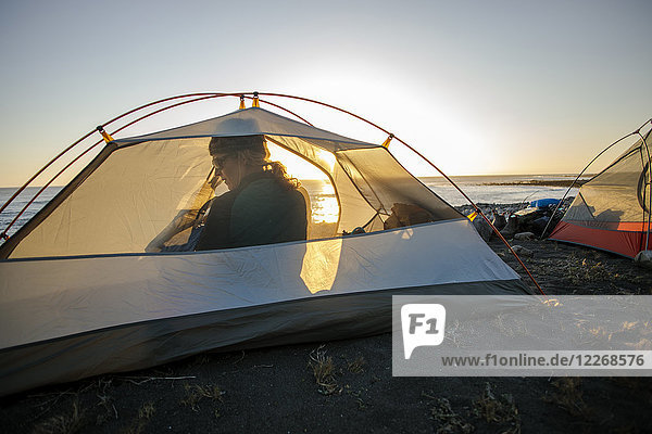 Woman sitting in camping tent on beach  Big Flat  Lost Coast Trail  Kings Range National Conservation Area  California  USA