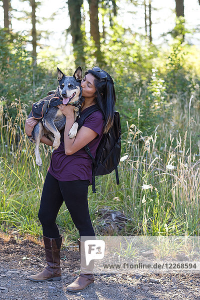Woman holding her dog up during hike in Oregon  USA