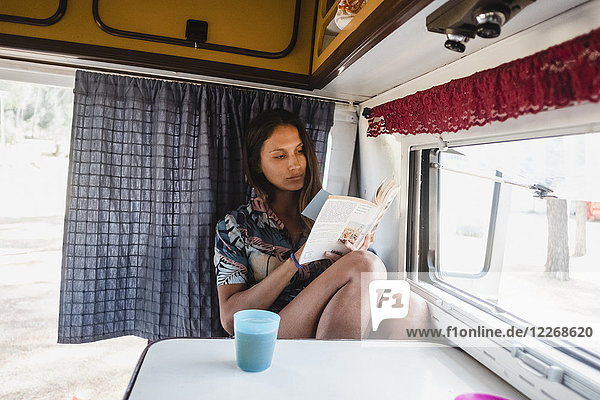 Frau liest Buch im Wohnmobil