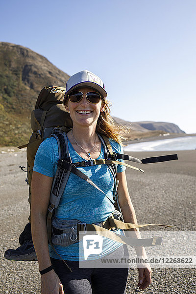 Portrait of female hiker standing on Lost Coast beach and smiling at camera  California  USA