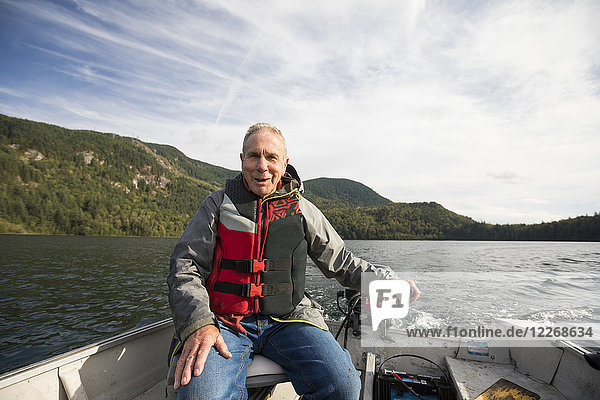 Fisherman sitting in motorboat  Hicks Lake  Harrison Hot Springs  British Columbia  Canada