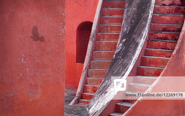 Nahaufnahme von zwei steilen Treppen,  die parallel an einem roten Gebäude hochführen.