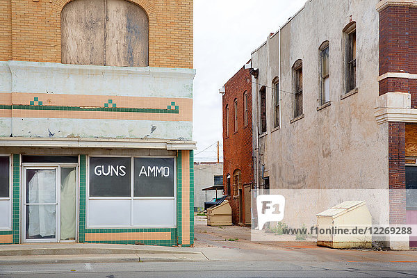 Fassade eines verlassenen Gebäudes an einer Straßenecke  Waffen- und Munitionsgeschäft.