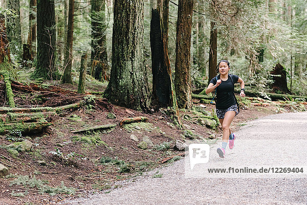 Woman running in forest  Vancouver  Canada