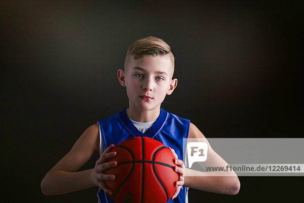 Junge hält Basketball