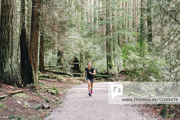 Woman running in forest  Vancouver  Canada