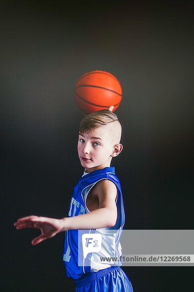 Junge will Basketball werfen