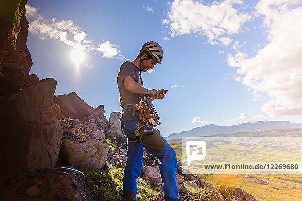 Junger männlicher Bergsteiger  der sich auf den Aufstieg vorbereitet  Narsaq  Vestgronland  Südgrönland