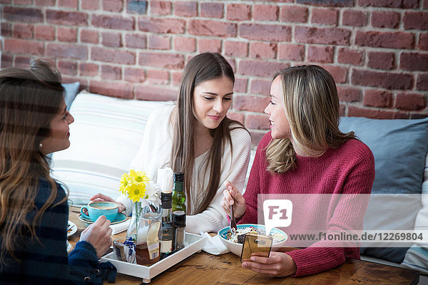 Drei Freundinnen  die zusammen im Café sitzen