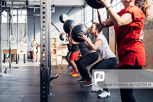 Group of people in gym using medicine balls