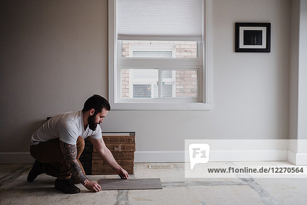 Man installing floor tiles