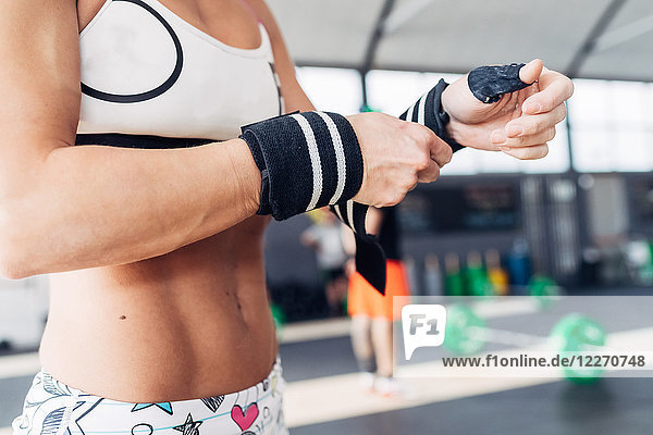 Cropped view of woman preparing for weightlifting  wearing gym gloves