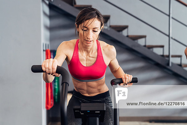 Woman in gym using exercise bike