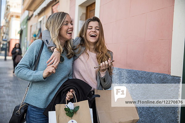 Freunde beim Einkaufen und Lachen auf der Straße