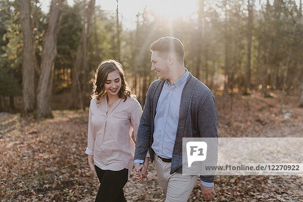Junges Paar hält sich an den Händen und geht im Wald spazieren  Ottawa  Kanada