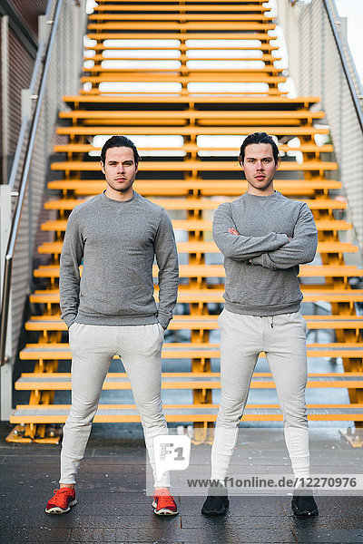 Junge erwachsene männliche Zwillinge  die zusammen trainieren  Treppenhaus-Portrait