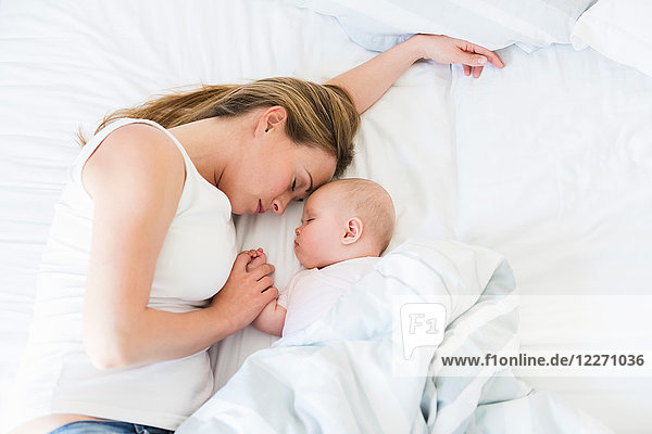 Mother and baby asleep in bed