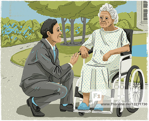 Mann im Anzug spricht mit älterer Frau im Rollstuhl
