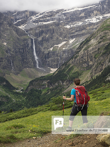 Woman hiking in the High Pyrenees with view over Cirque de Gavarnie  France