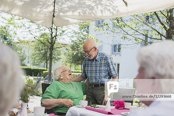 Senior people embracing on breakfast table