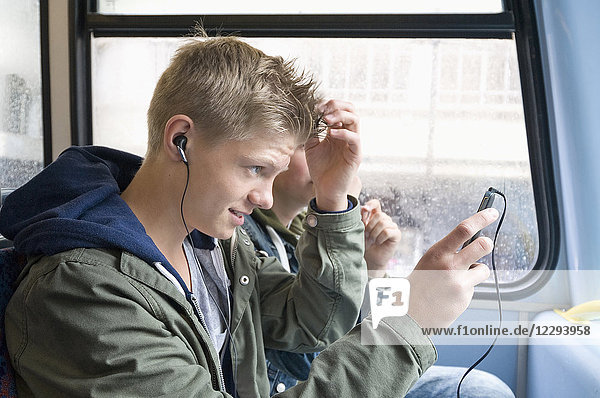 Junge frisiert sein Haar im öffentlichen Bus  London