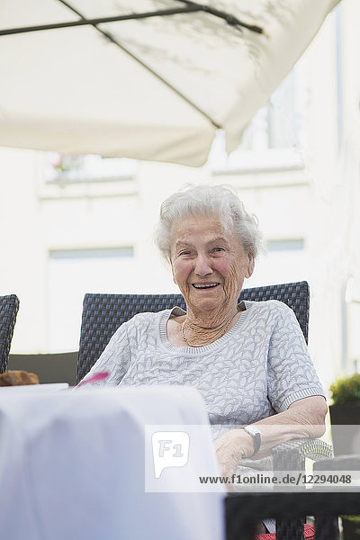 Porträt einer älteren Frau  die auf einem Tisch sitzt