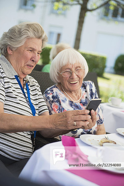 Senior women laughing and looking at smartphone