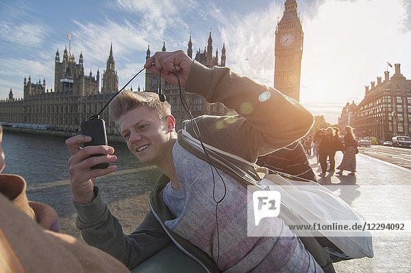Junge fotografiert seinen Freund auf einer Brücke mit einer Handykamera  London  Vereinigtes Königreich