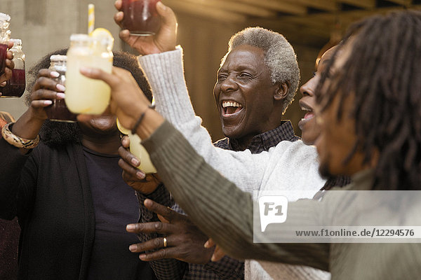 Happy  enthusiastic multi-generation family toasting lemonade and sangria