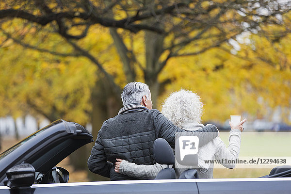 Seniorenpaar mit Cabrio im Herbstpark