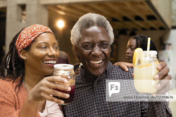 Glücklicher Senior Vater und Tochter trinken Limonade und Sangria
