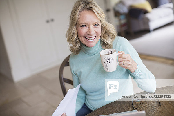 Portrait smiling confident mature woman drinking tea