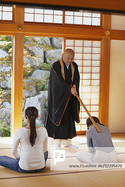 Japanischer Priester predigt zu Frauen in einem Tempel