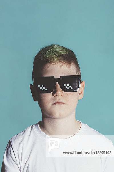Junge mit Sonnenbrille auf blauem Hintergrund