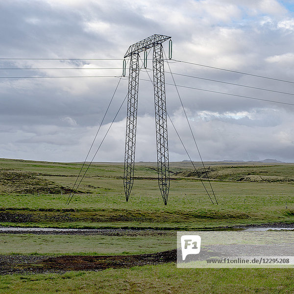Strommast auf grüner Wiese gegen bewölkten Himmel,  Hochland,  Island