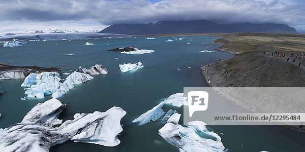 Scenic view of icebergs in water against cloudy sky  Jökulsárlón  Iceland