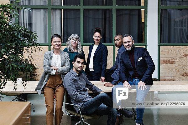 Portrait of confident business team at table in creative office