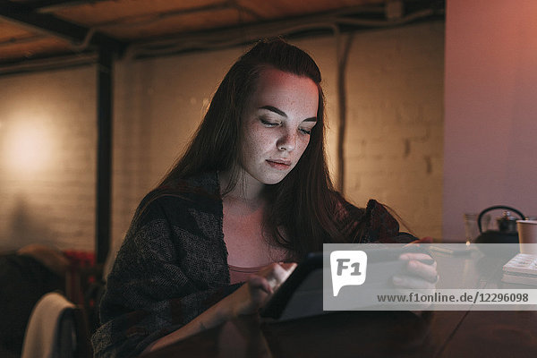 Schöne junge Frau mit digitalem Tablett im Cafe