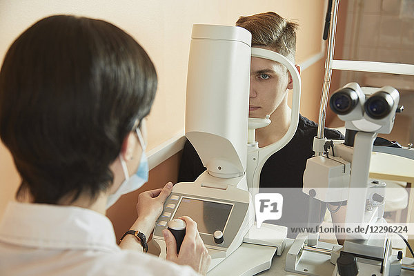 Optometrikerin untersucht das Auge des Patienten im Krankenhaus