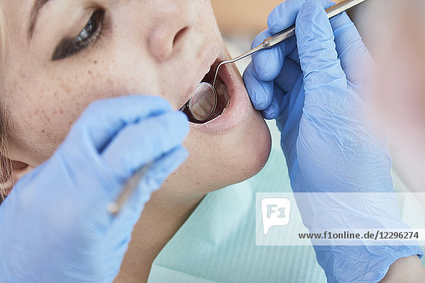 Beschnittenes Bild des Zahnarztes bei der Untersuchung des Patientenmundes im Krankenhaus