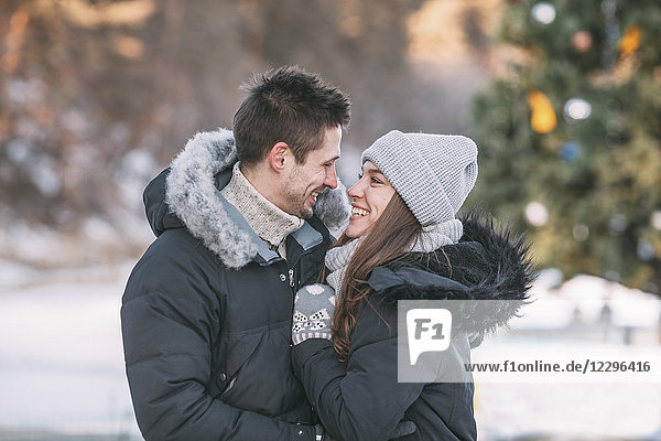 Lächelndes Paar in warmer Kleidung im Freien stehend