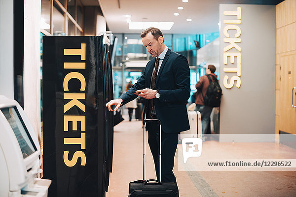 Mature businessman buying tickets in airport