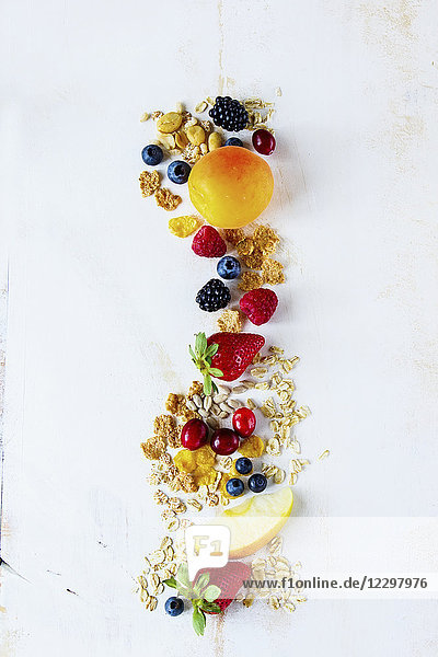 Nahaufnahme von leckeren Frühstücks- oder Smoothie-Zutaten. Verschiedene Körner  Samen  frische Beeren und Früchte auf weißem  rustikalem Hintergrund