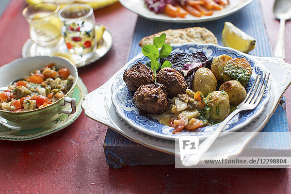 Vorderasiatisches Abendessen mit Kichererbsen-Falafel  Mutabal-Dip  Bratkartoffeln und Rote-Bete-Chips