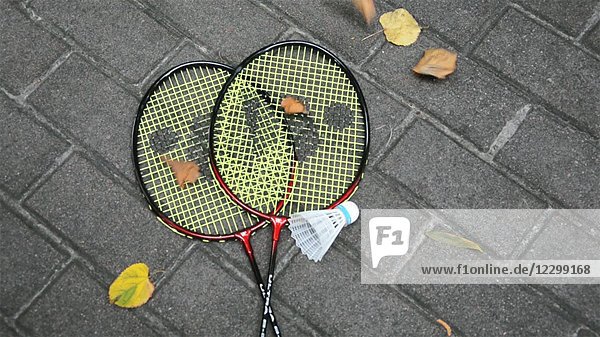 High Angle View of Autumn Leaves Falling on Two Badminton Racquets and Shuttlecock