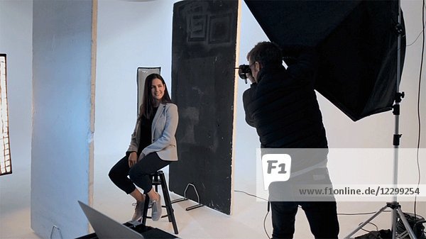 Fotograf schießt Porträt einer jungen erwachsenen Frau im Fotostudio
