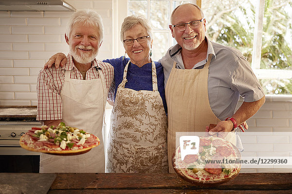 Portrait smiling  confident senior friends making pizza in cooking class