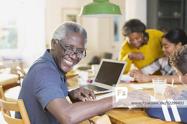 Portrait smiling  confident senior man using laptop with family
